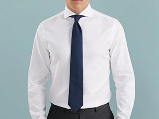 Man in white shirt with plain navy tie